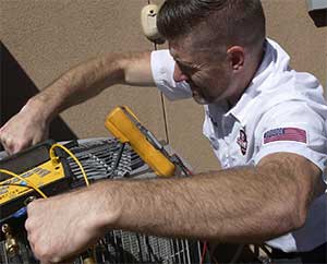 Perfect Star Heating and Air Conditioning Concord, CA Owner, Chris Donzelli servicing a client’s air conditioning unit in Brentwood, CA